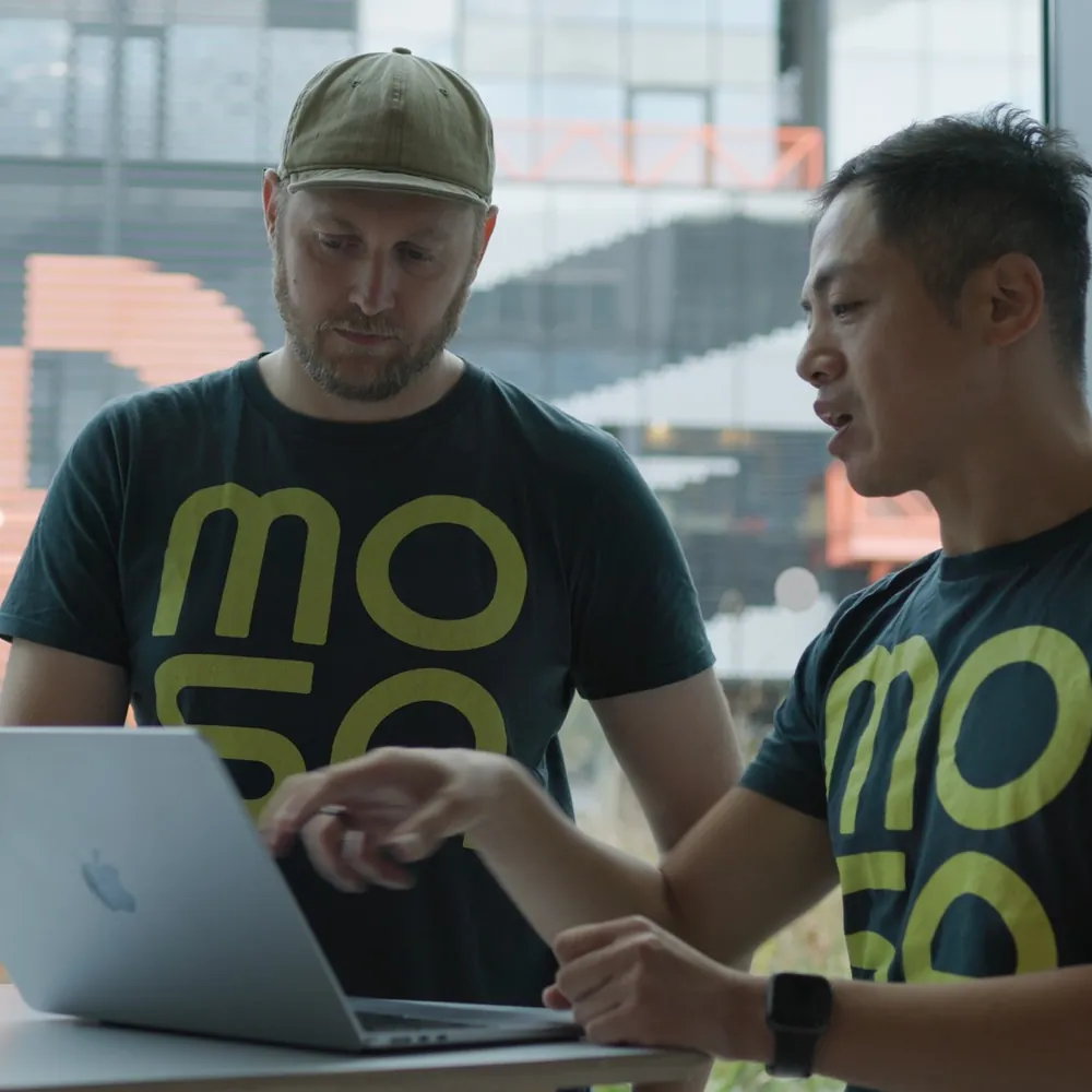 Two of the Mosa team going through a plan together on a laptop.